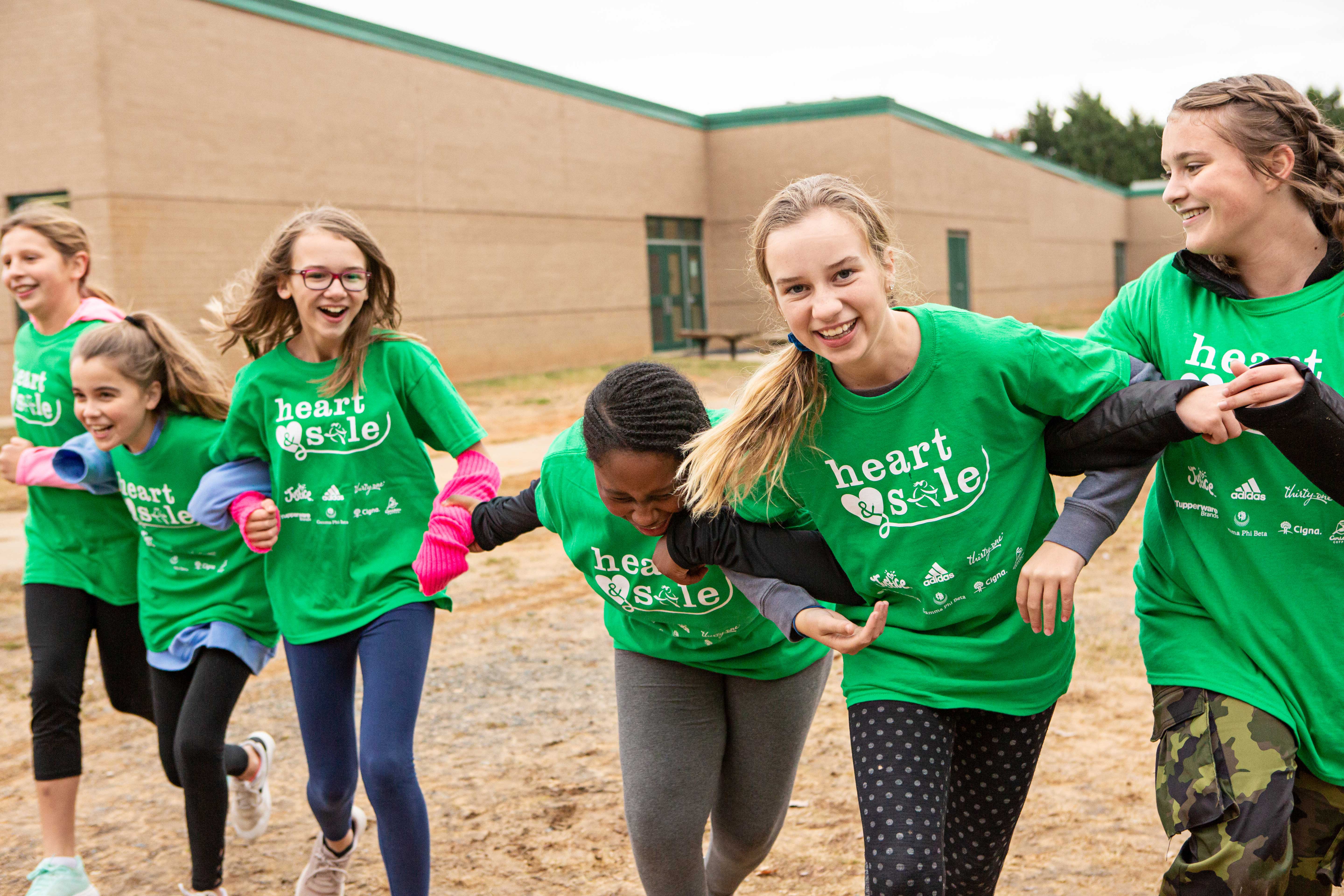 Heart & Sole girls in green shirts laughing.